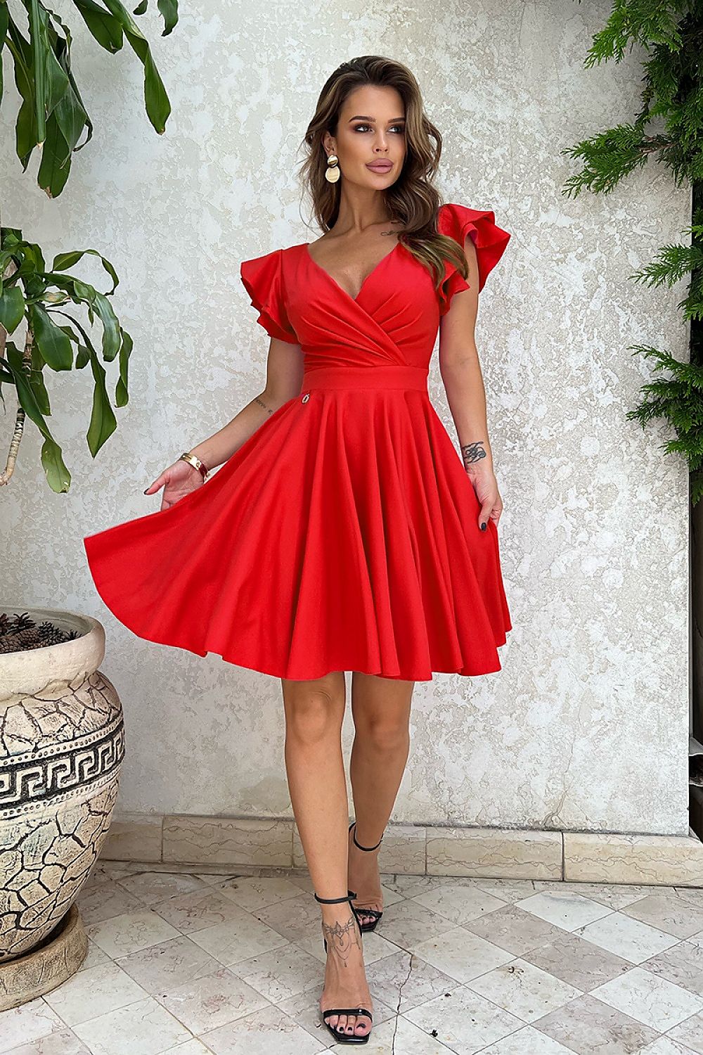 Vrouw in Ruffle Charm taillejurk met ruches aan de mouwen β elegante meisjesachtige jurk