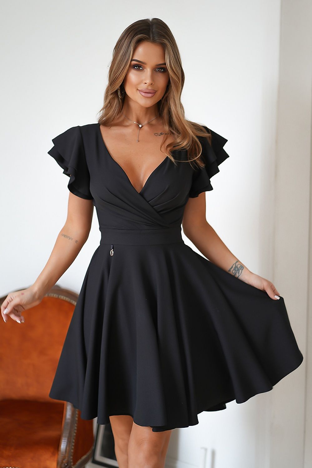 Vrouw in Ruffle Charm taillejurk met ruches aan de mouwen β elegante meisjesachtige jurk