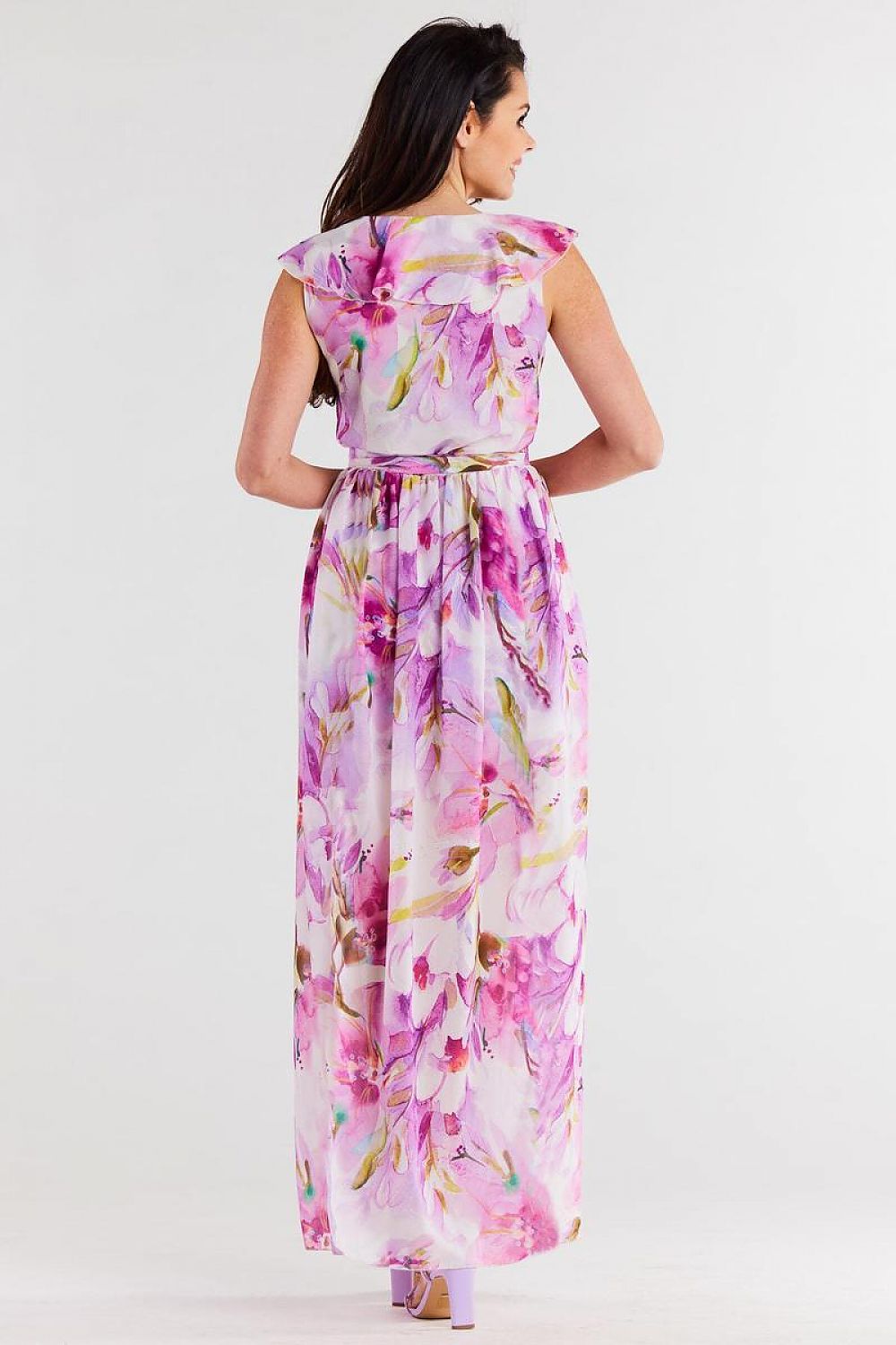 Vrouw draagt Flair Élan asymmetrische chiffonjurk met ruche, ceintuur en elegante splitten.