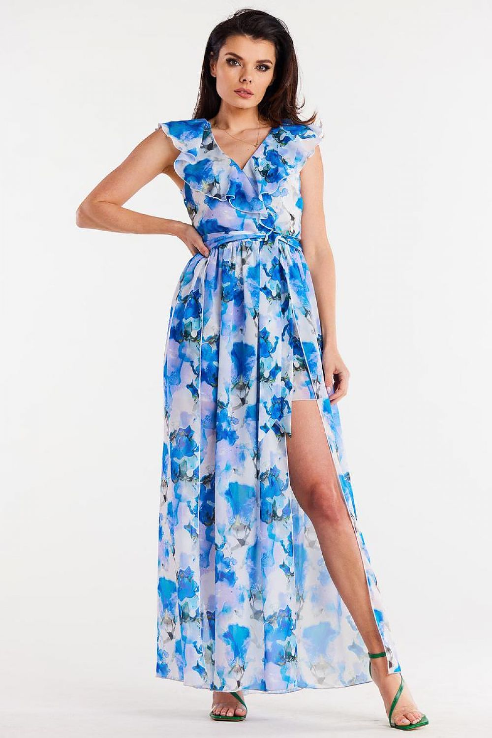 Vrouw draagt Flair Élan asymmetrische chiffonjurk met ruche, ceintuur en elegante splitten.