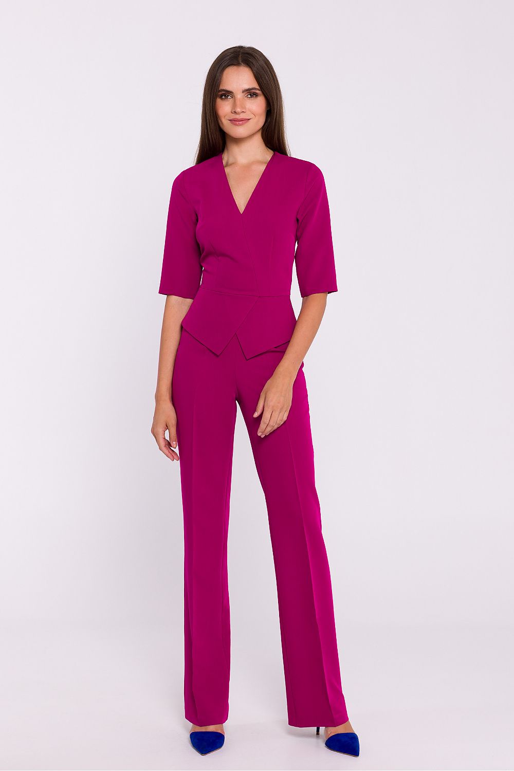 Vrouw draagt Viva Élégance jumpsuit met V-hals en wijde pijpen – chique dames jumpsuit met elegante pasvorm en vrouwelijke uitstraling.