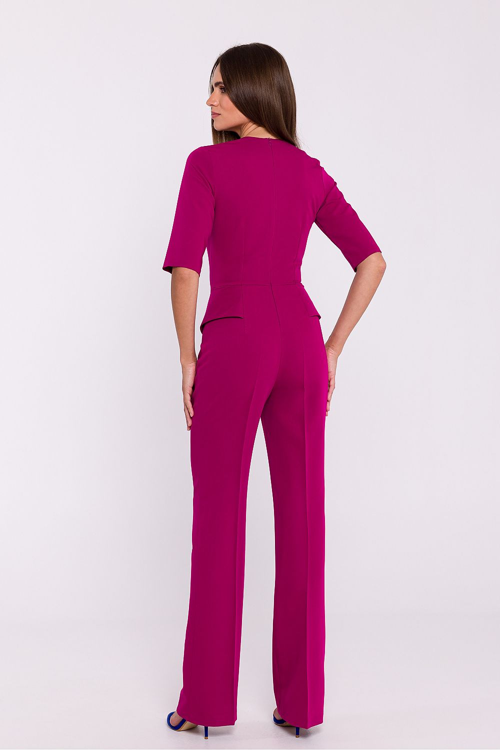 Vrouw draagt Viva Élégance jumpsuit met V-hals en wijde pijpen – chique dames jumpsuit met elegante pasvorm en vrouwelijke uitstraling.