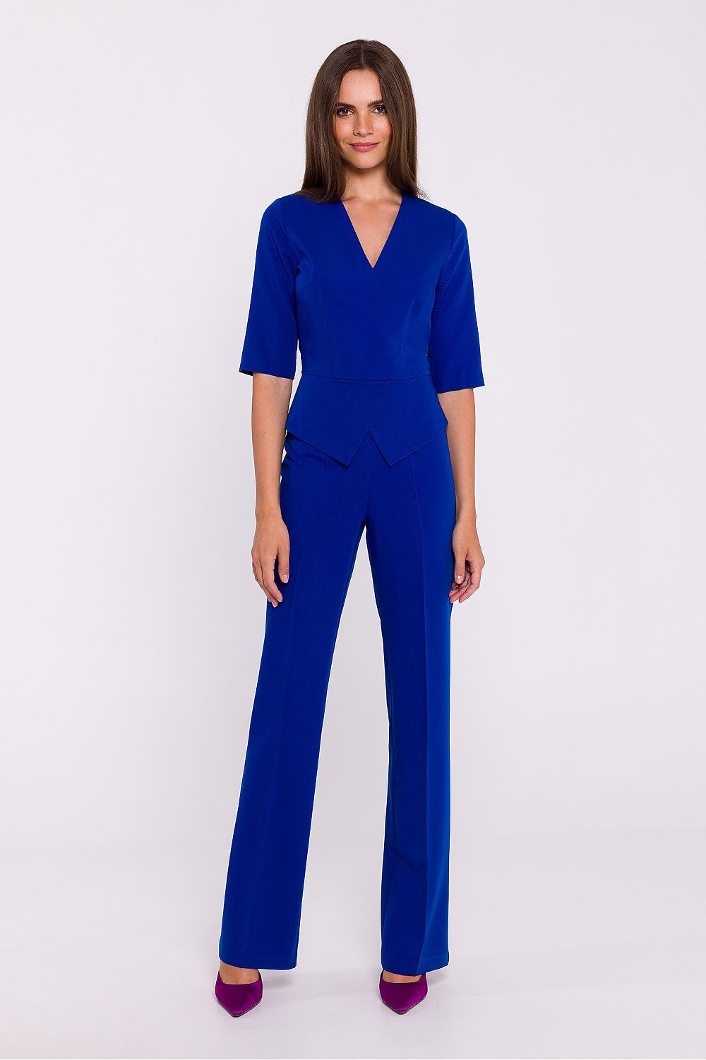 Vrouw draagt Viva Élégance jumpsuit met V-hals en wijde pijpen – chique dames jumpsuit met elegante pasvorm en vrouwelijke uitstraling.