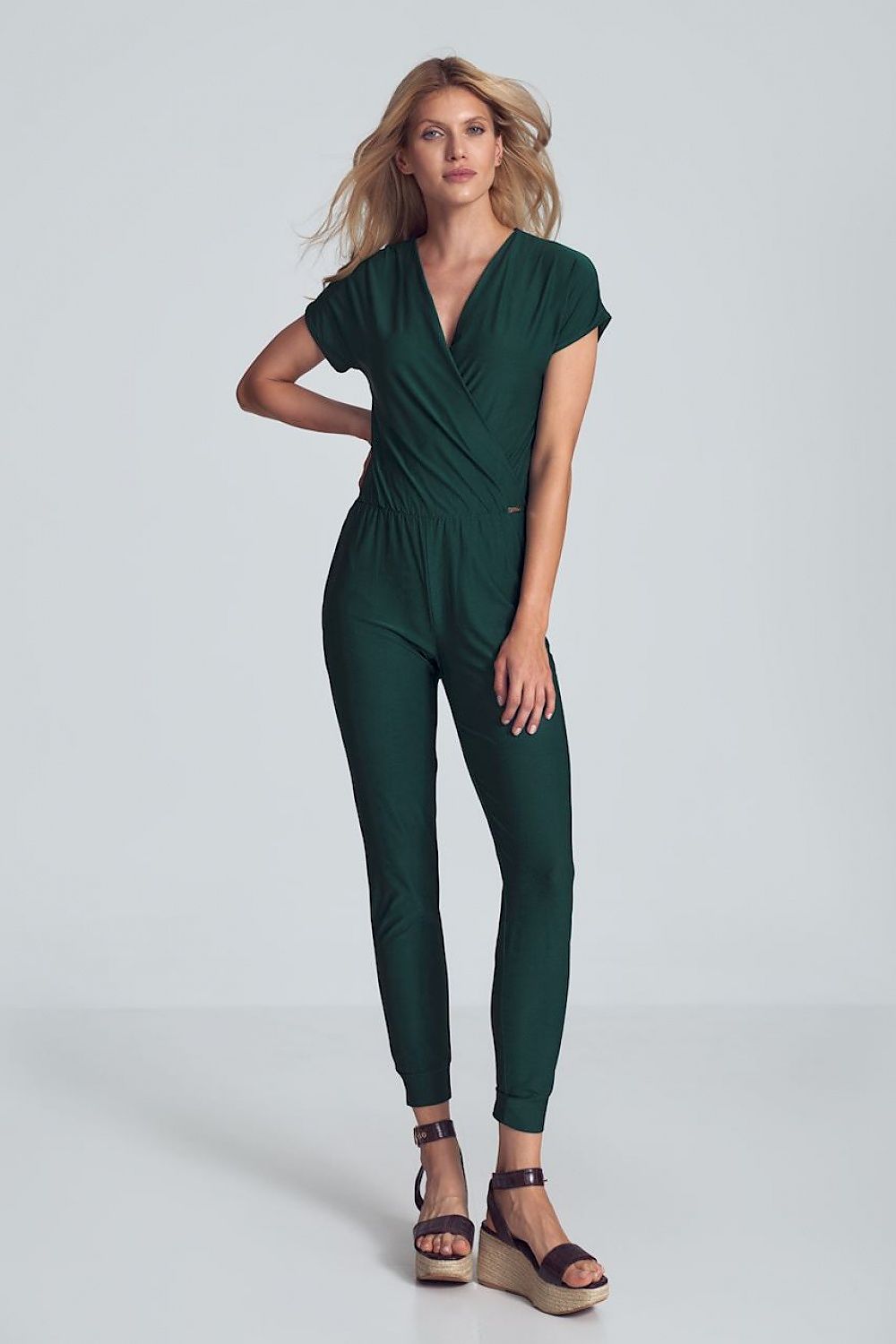Groene jumpsuit met crinkle halslijn, elastische taille en taps toelopende pijpen met drawstring.