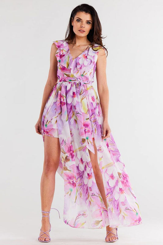 Vrouw draagt Flair Élan asymmetrische chiffonjurk met ruche, ceintuur en elegante splitten.