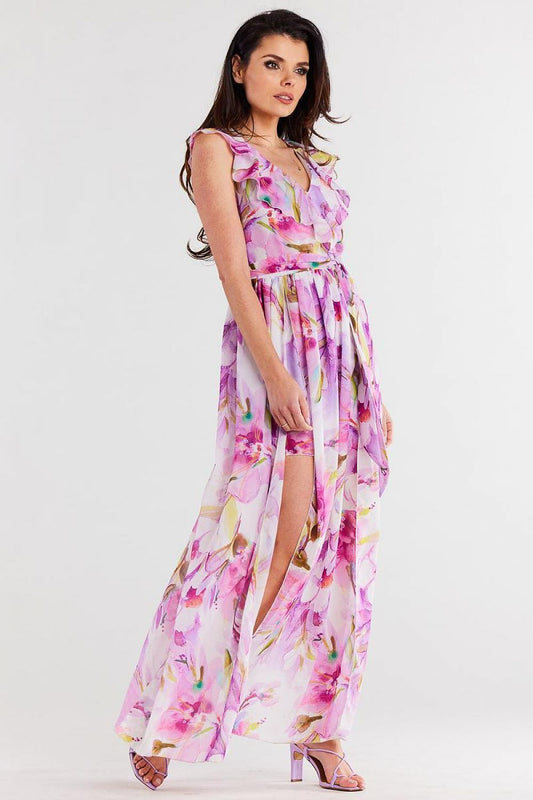 Vrouw draagt Flair Élan asymmetrische chiffonjurk met ruche, ceintuur en elegante splitten.