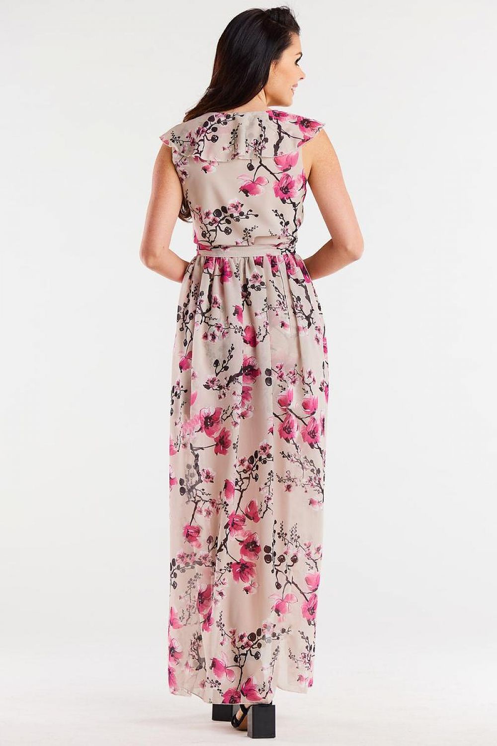 Vrouw draagt Flair Élan asymmetrische chiffonjurk met ruche, ceintuur en elegante splitten.