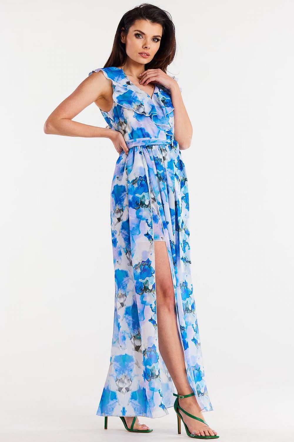 Vrouw draagt Flair Élan asymmetrische chiffonjurk met ruche, ceintuur en elegante splitten.