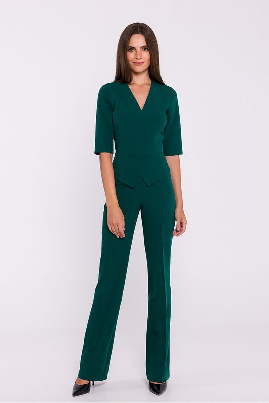 Vrouw draagt Viva Élégance jumpsuit met V-hals en wijde pijpen – chique dames jumpsuit met elegante pasvorm en vrouwelijke uitstraling.