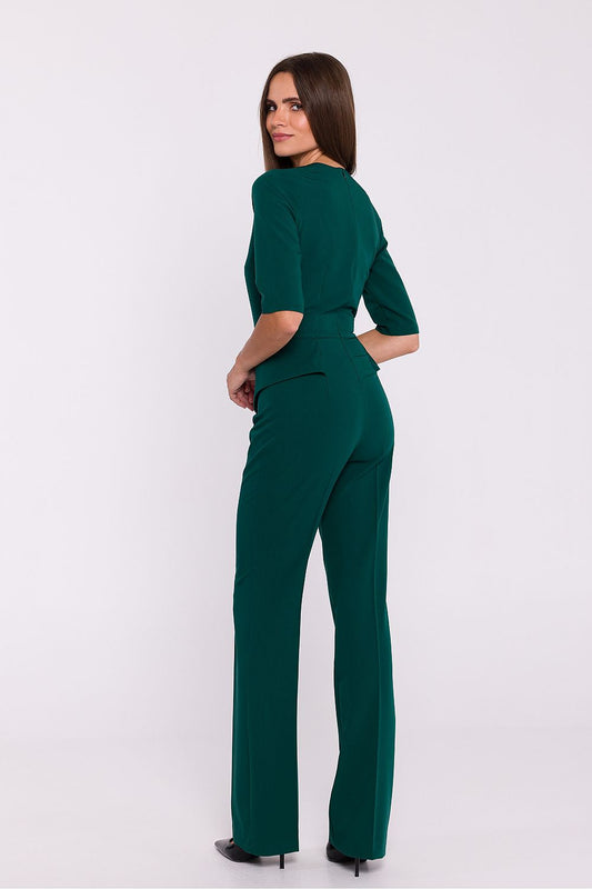 Vrouw draagt Viva Élégance jumpsuit met V-hals en wijde pijpen – chique dames jumpsuit met elegante pasvorm en vrouwelijke uitstraling.
