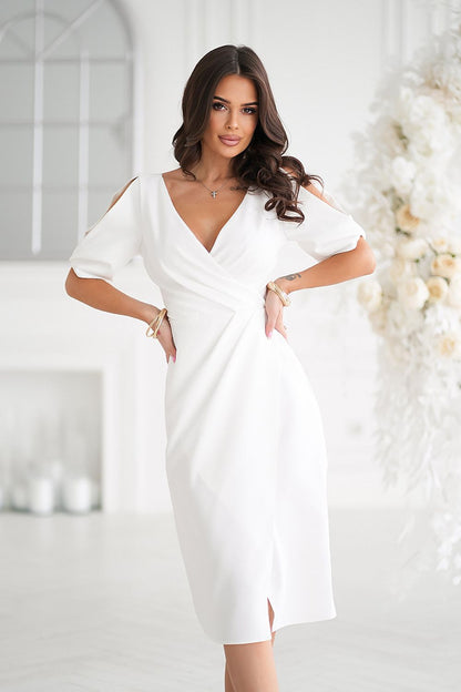 Elegante getailleerde jurk met overslaghals, split aan de voorkant en mouwen met split – perfect voor speciale gelegenheden.