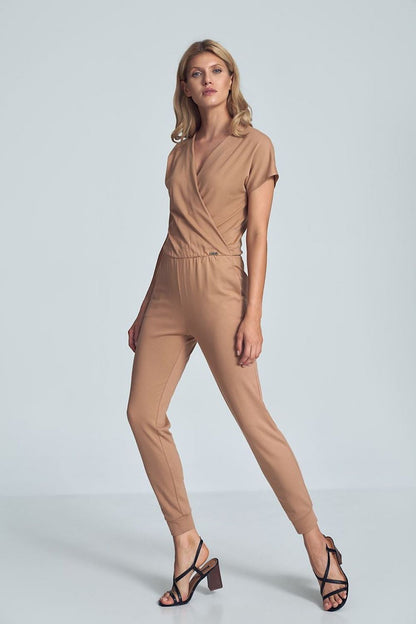 Beige jumpsuit met crinkle halslijn, elastische taille en taps toelopende pijpen met drawstring.